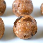 Six homemade raw cookie dough energy balls with chocolate chips.