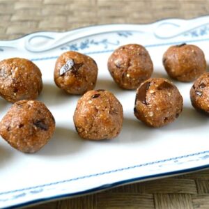 Intersection of two rows of chocolate chip cookie dough energy balls on a rectangular platter.