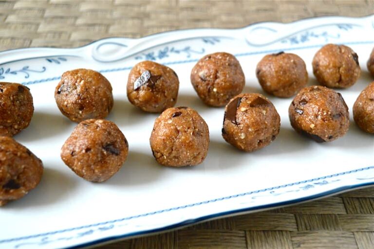 Intersection of two rows of chocolate chip cookie dough energy balls on a rectangular platter.
