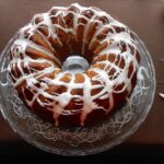 A fig and mincemeat Christmas bundt cake with icing on a cake stand.