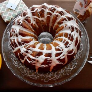 A fig and mincemeat Christmas bundt cake with icing on a cake stand.