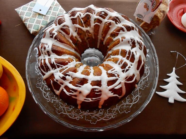 A fig and mincemeat Christmas bundt cake with icing on a cake stand.