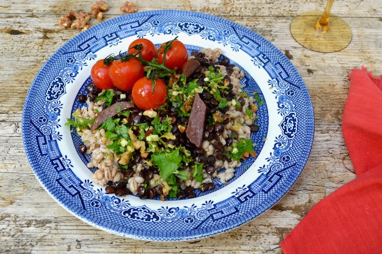 A plate of barley lentil dinner with roasted tomatoes and walnut gremolata.