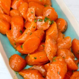 Close up of a platter of honey butter glazed carrots.