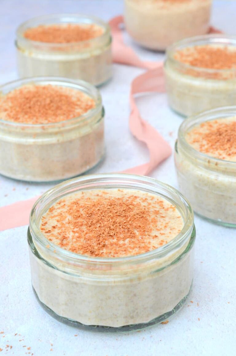 Six pots of banana chia pudding with chocolate grated over the top.