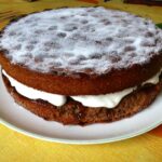 A hot chocolate Victoria sandwich sponge cake with an apricot jam and whipped cream filling.