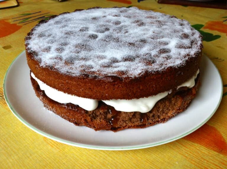 A hot chocolate Victoria sandwich sponge cake with an apricot jam and whipped cream filling.