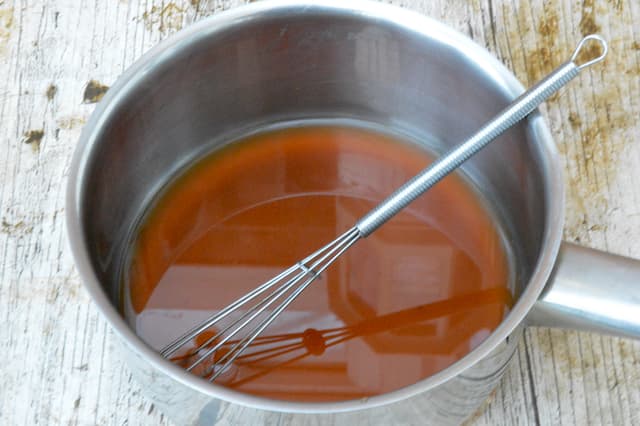 A small pan and whisk with coconut sugar dissolved in Champagne.
