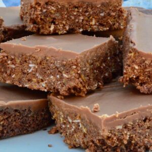 Chocolate cornflake coconut crunch bars stacked on a plate.
