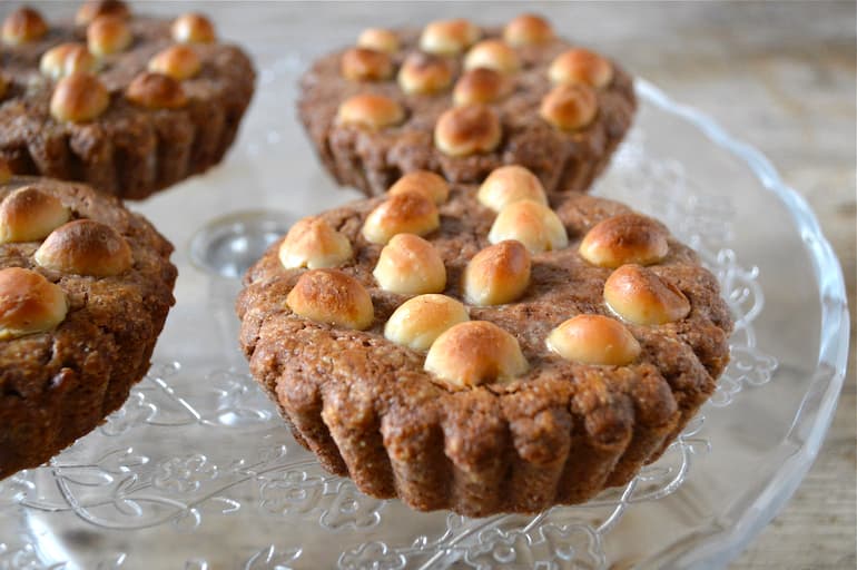 Two giant filled chocolate macadamia nut cookies on a glass plate.