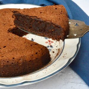 A slice of chocolate polenta cake lifted from the plate.