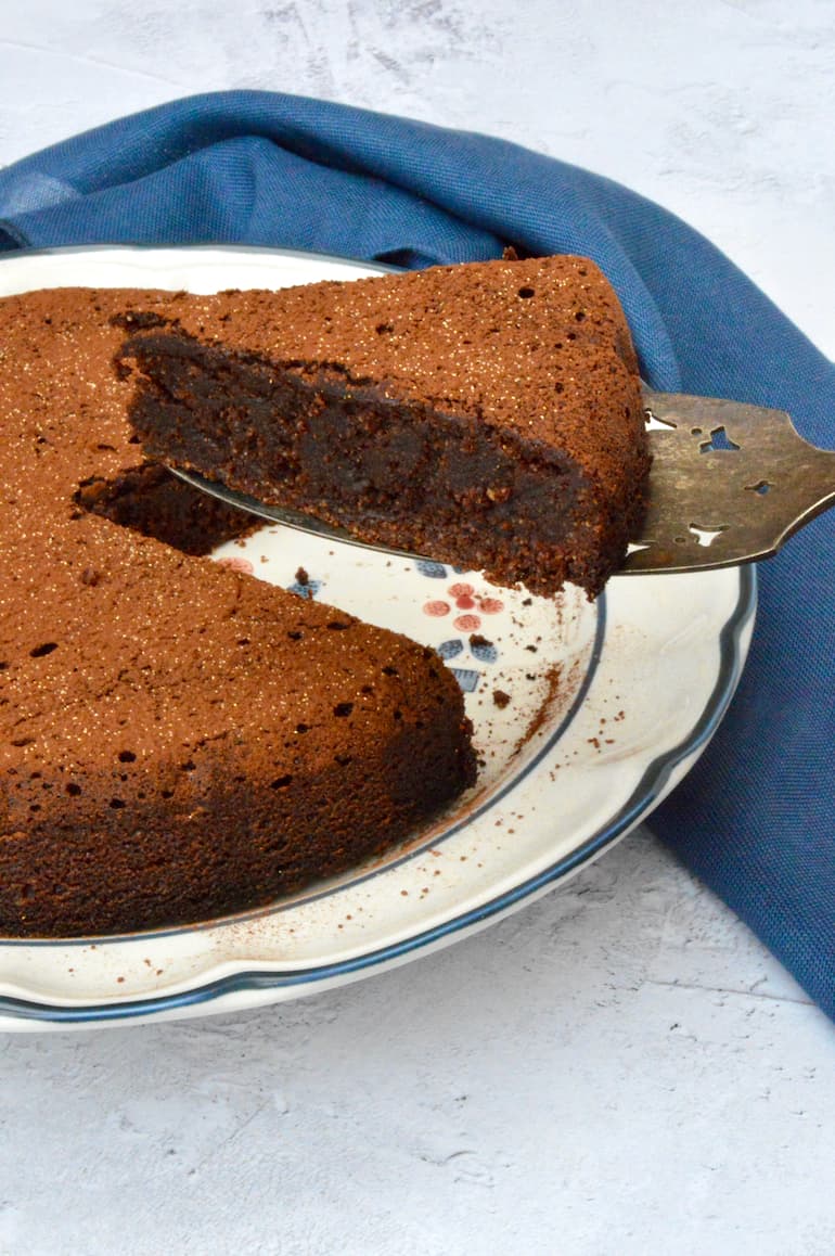 A slice of chocolate polenta cake lifted from the plate.