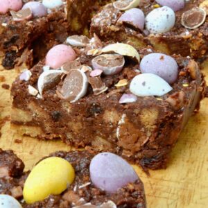 Close up of easy to make Easter tiffin bars (no-bake fridge cake) with smashed mini eggs on top.
