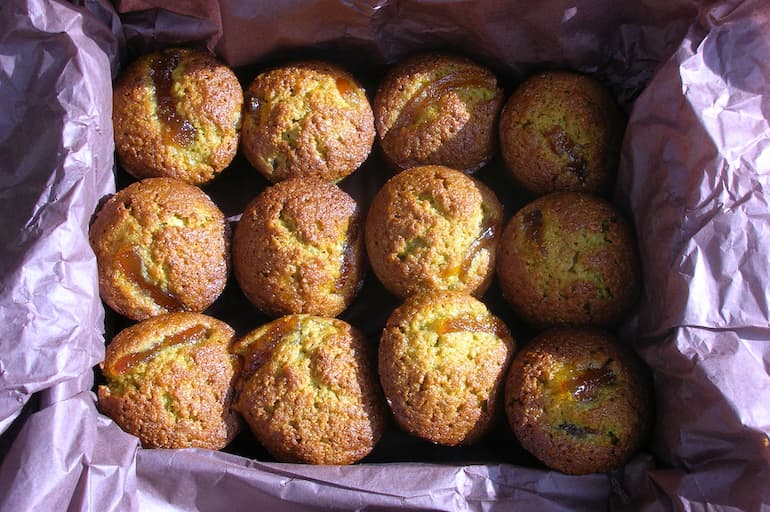Mini matcha marmalade cakes in a basket lined with tissue paper.