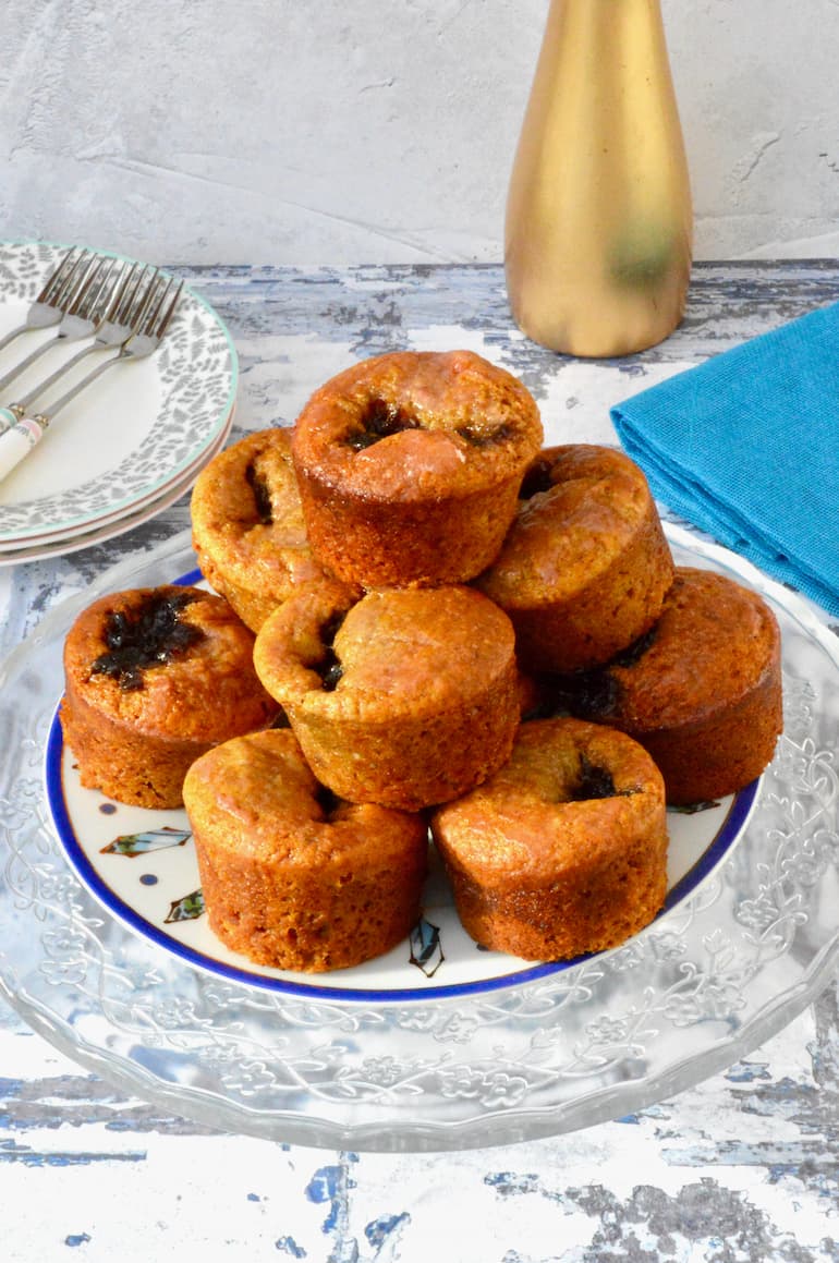 A stack of egg-free French honey cakes, aka nonnettes with plates and cake forks to one side.