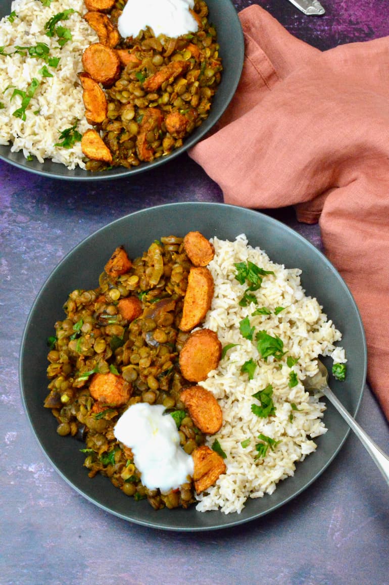 Two bowls of roasted carrots and lentil curry with rice and a dollop of yoghurt.