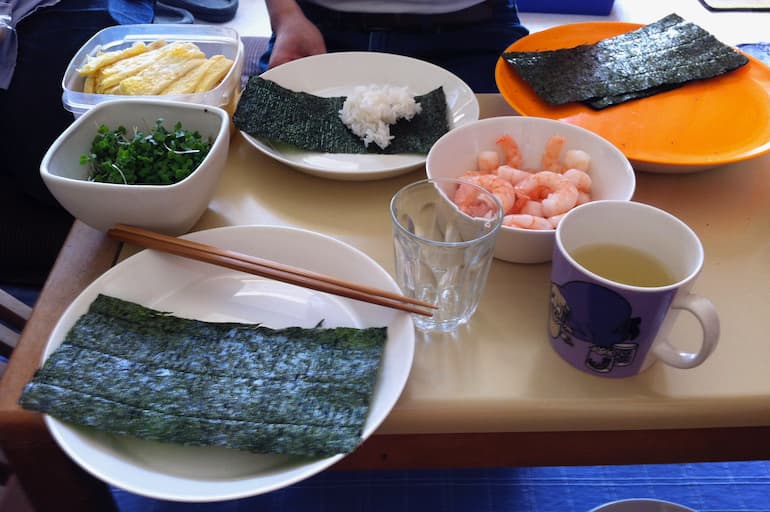 Various sushi ingredients laid out to fill nori rolls.
