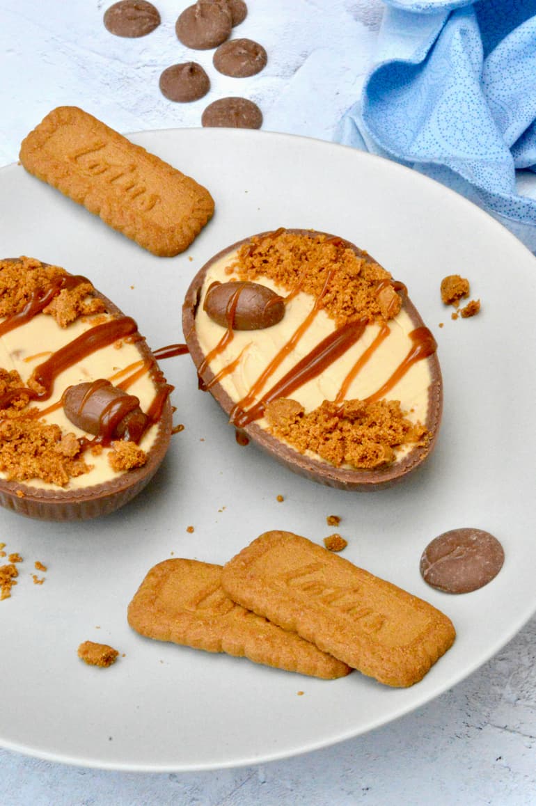 Two Biscoff cheesecake filled Easter eggs decorated with salted caramel.