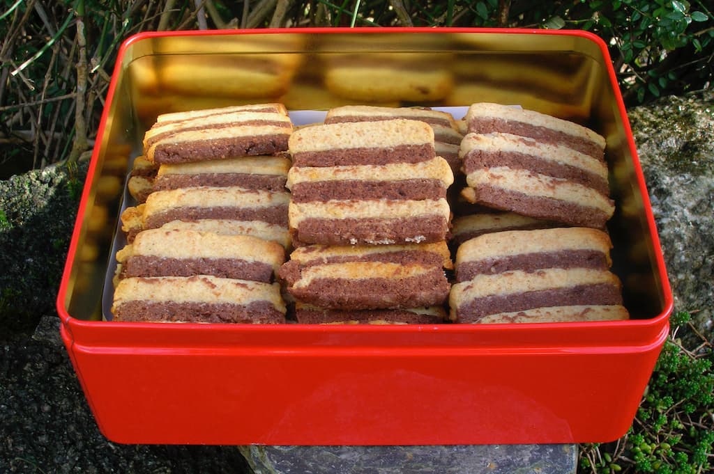 Homemade zebra cookies in a red biscuit tin.