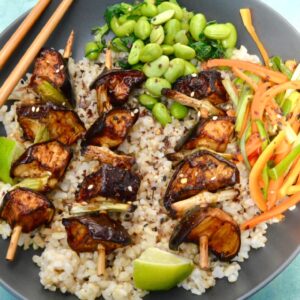 3 aubergine yakitori on a bed of short grain brown rice with edamame beans and carrot salad.