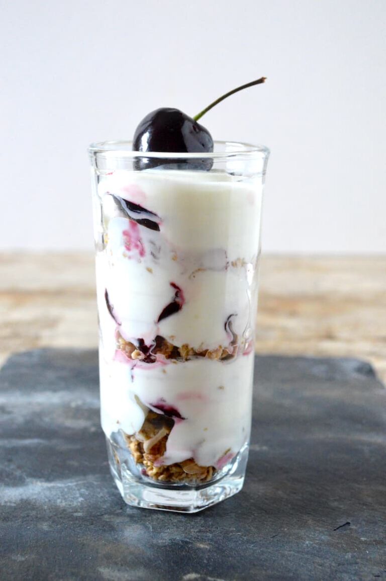 Cherry granola pot in a glass with a cherry on top.