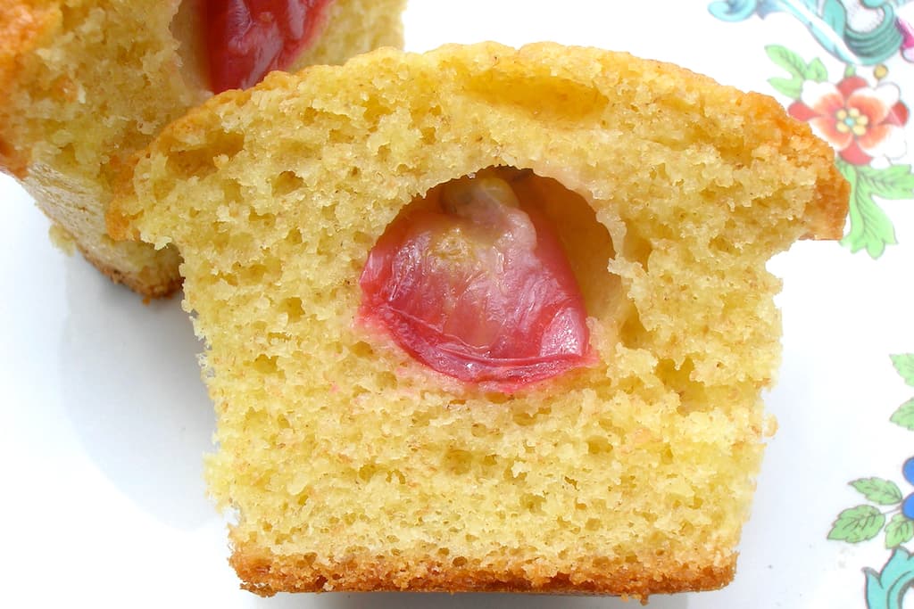 A red gooseberry cake - halved and showing the gooseberry in the middle.