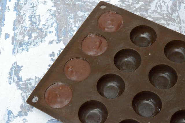 Frozen ganache in four silicone chocolate moulds.
