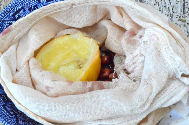 Lemon rind and stone fruit pits in muslin bag.