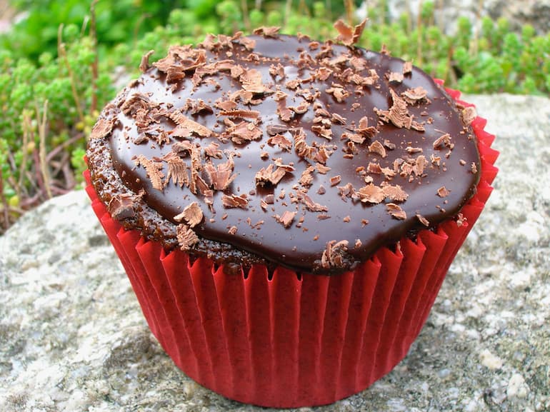 A chilli chocolate cupcake with a dark chocolate ganache in a red case.