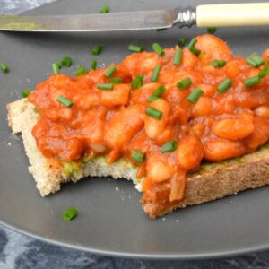 Homemade baked beans on toast with a bite taken out.