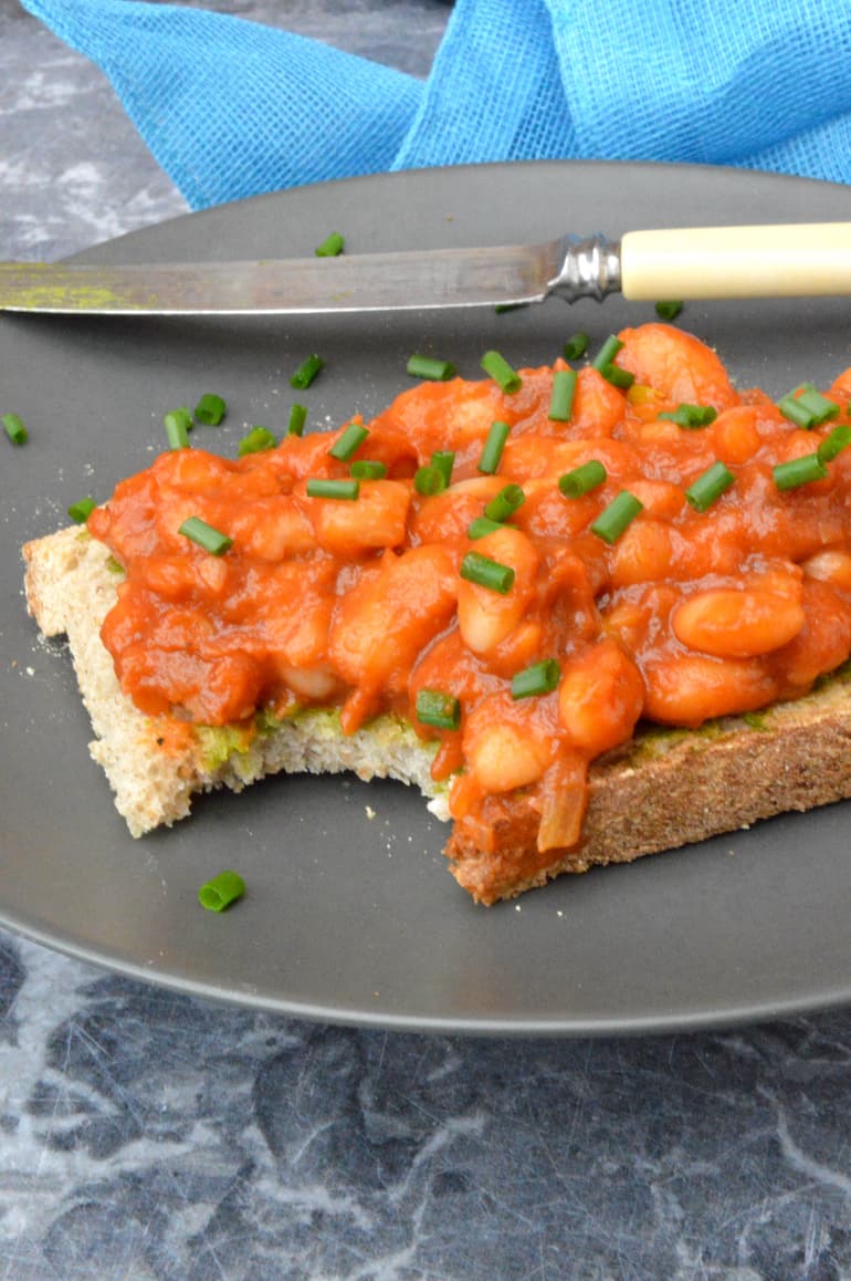 Homemade baked beans on toast with a bite taken out.