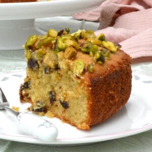 A slice of dried apricot and almond cake with a sticky pistachio topping.