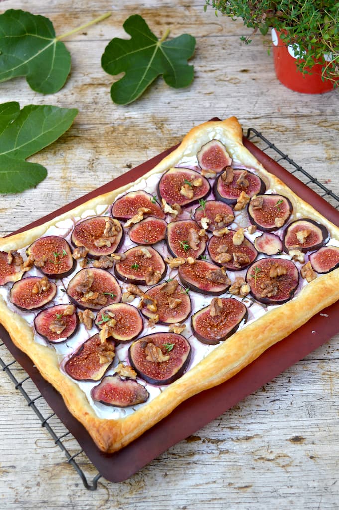 A puff pastry fig and goat's cheese tart with walnuts, thyme  and honey on a cooling rack.