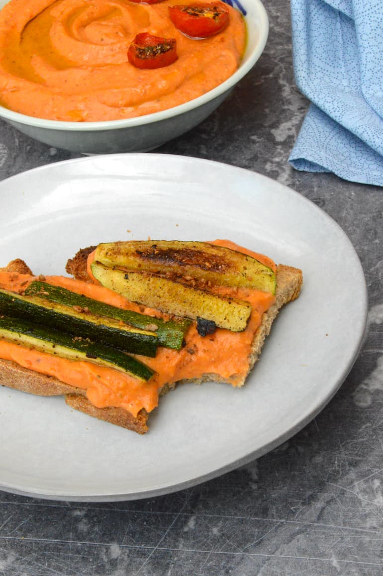 Roasted tomato and white been dip on bitten toast topped with fried courgettes.