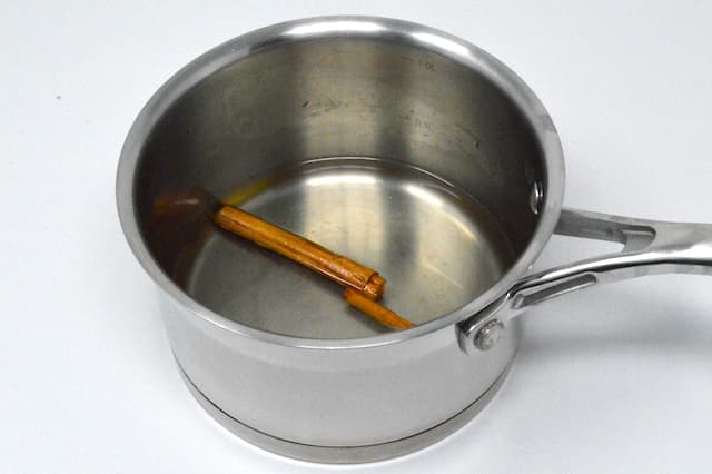 Cinnamon stick in a saucepan of simple syrup.