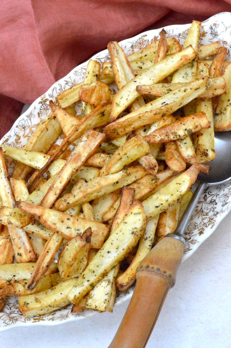 Partial view of a plate of air fryer parsnip chips with spoon.