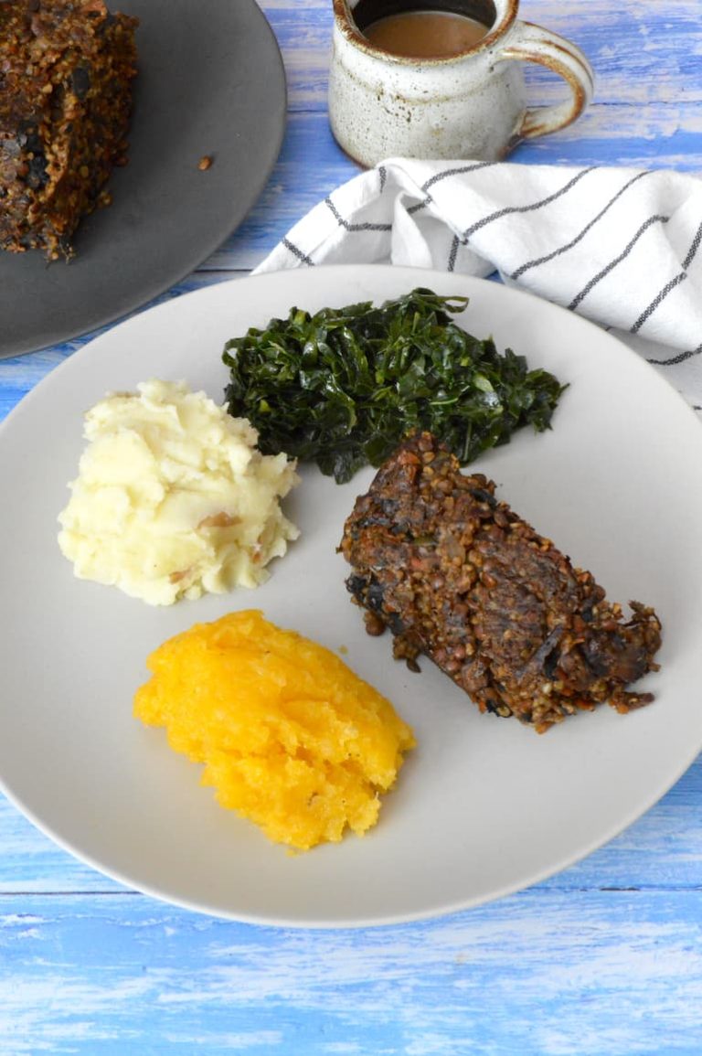 Easy vegan haggis on plate with neeps, tatties and kale.