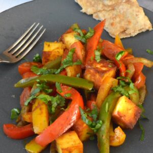 Easy homemade paneer jalfrezi on plate with fork and bread.
