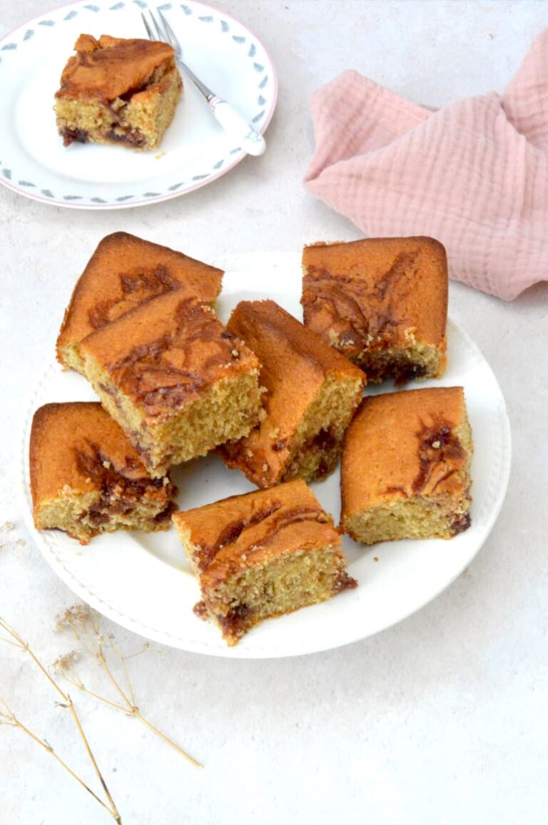 A jumble of peanut butter and jelly traybake squares on a plate.