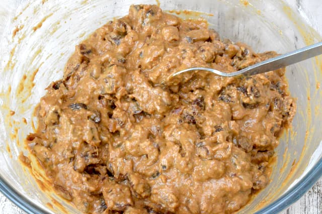 Cake batter mixed in glass bowl with spoon.