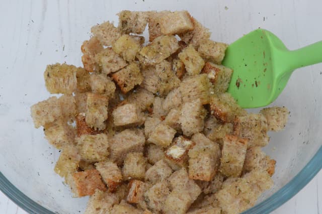 Cubed sourdough in bowl with dressing ingredients.