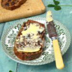 Slice of simple tea bread spread with salted butter.