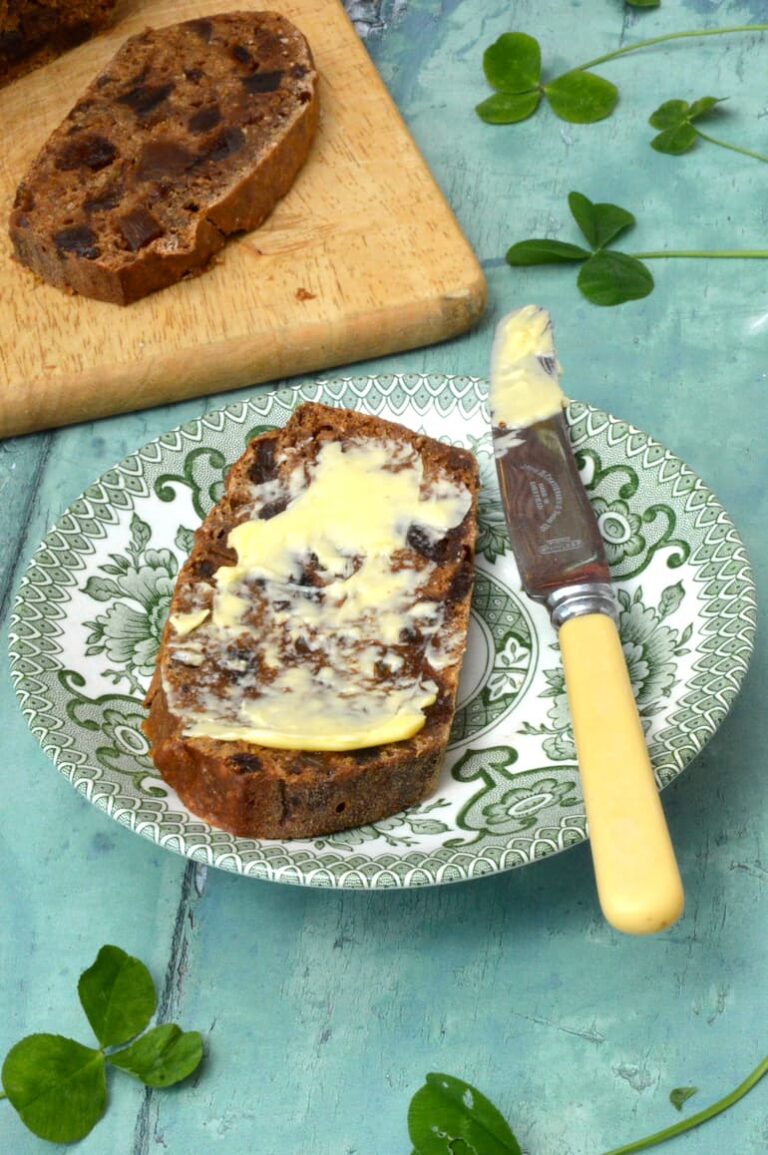 Slice of simple tea bread spread with salted butter.