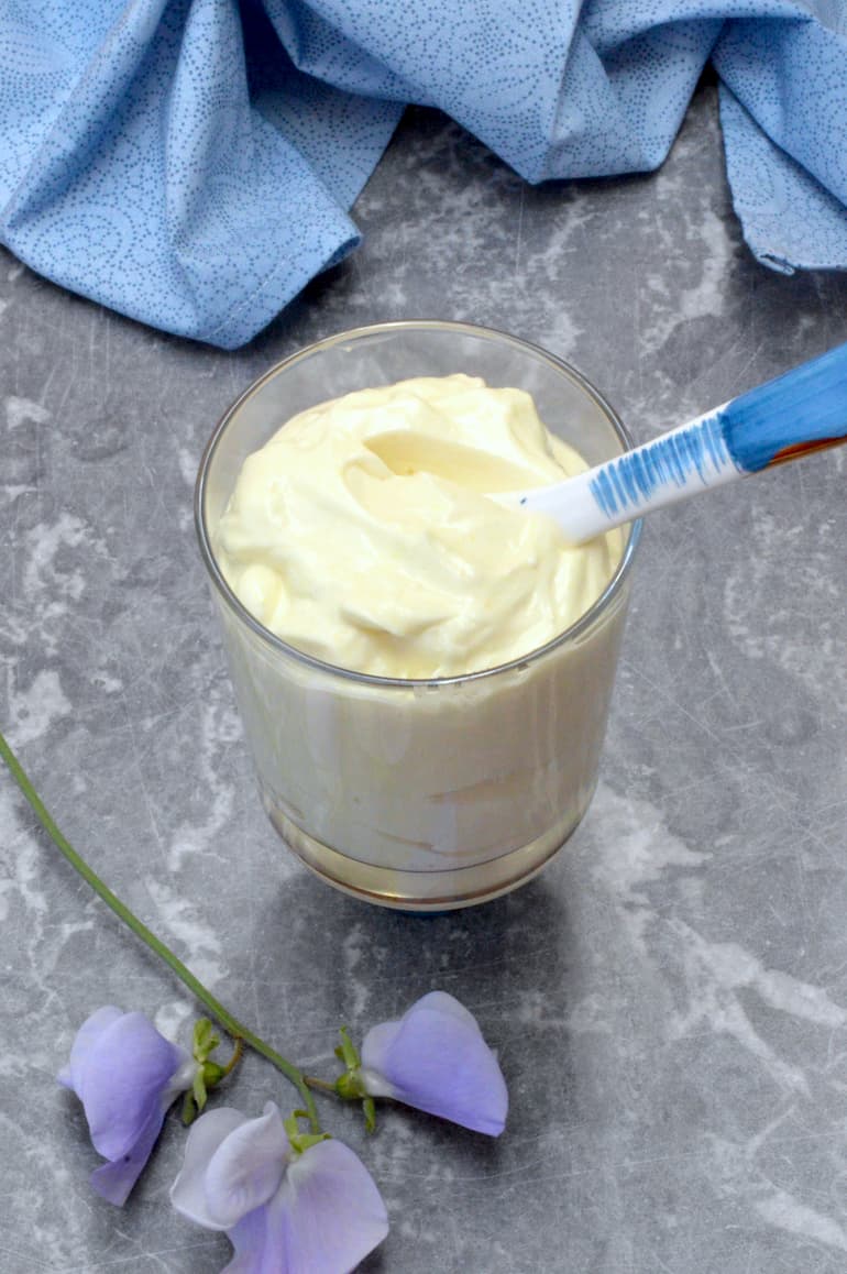 Vegan mayonnaise in a jar with spoon.