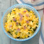 A bowl of egg and sweetcorn mayo decorated with chive flowers.