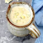 A jug of blue cheese sauce with crumbled stilton on top.