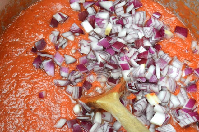 Diced red onions added to pan.