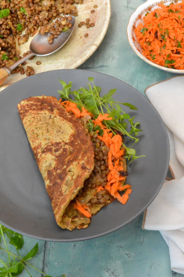 Simple vegan lentil mince in folded flatbread with carrot salad and chickweed.