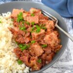 Bowl of tempeh curry with leeks and fork.