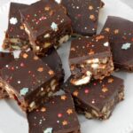 Squares of Christmas tiffin piled on a plate.